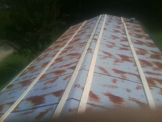 Rusted metal roof panels with new wood purlins before replacement — Storm Damage Roof Repair in Port Deposit by Roofing Brothers
