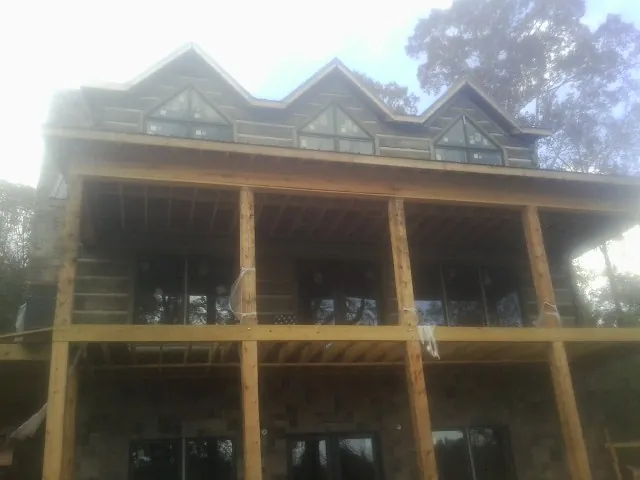 Dormers and porch framing on a large log home under construction — Roof Coating work by our crew in Port Deposit